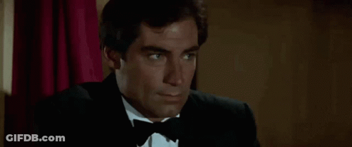 Man In Tuxedo And Bow Tie Sitting In Chair GIF