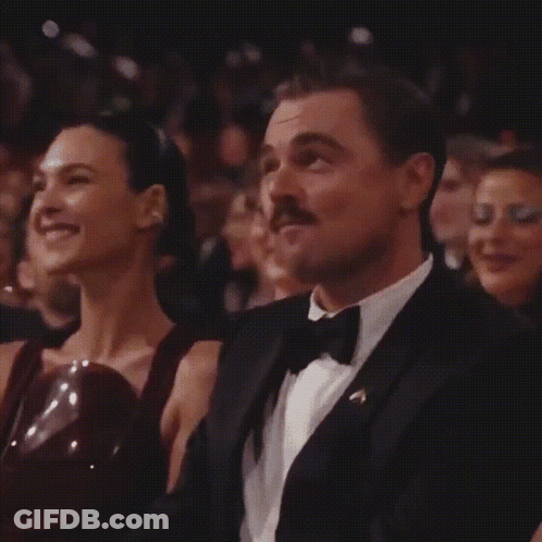 Man In Tuxedo And Bow Tie Sitting Next To Woman GIF