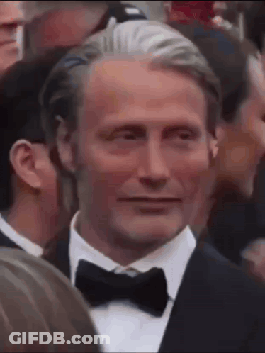 Man In Tuxedo And Bow Tie Smiling In Crowd GIF
