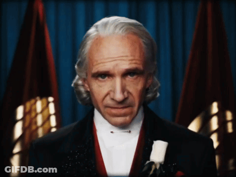Man In Tuxedo And Bow Tie With Two Flags GIF