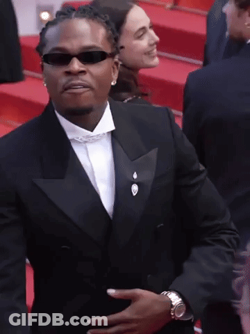 Man In Tuxedo And Sunglasses Holding Stomach GIF