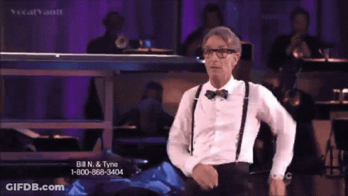 Man In Tuxedo And Suspenders With Baton Says Science GIF