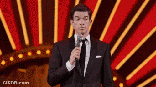 Man In Tuxedo And Tie Holding Microphone GIF