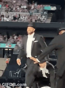 Man In Tuxedo And Top Hat Dancing Before Crowd GIF