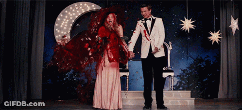 Man In Tuxedo And Woman In Red Dress Holding Hands GIF