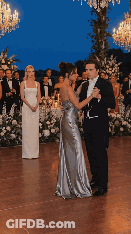 Man In Tuxedo And Woman In Silver Dress Dancing GIF