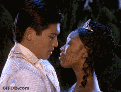 Man In Tuxedo And Woman In Tiara Kissing GIF