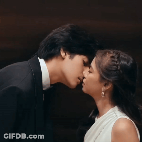 Man In Tuxedo And Woman In White Dress Kissing GIF