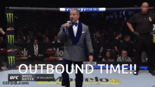 Man In Tuxedo At Microphone With Outbound Time GIF