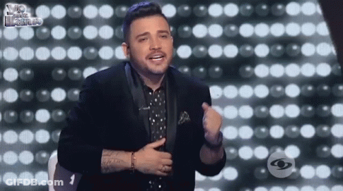 Man In Tuxedo Before Wall Of Lights GIF