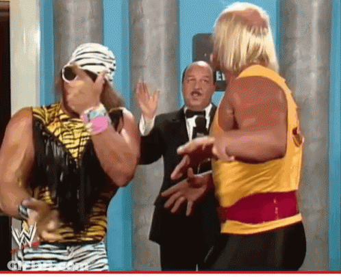 Man In Tuxedo Beside Wrestler GIF