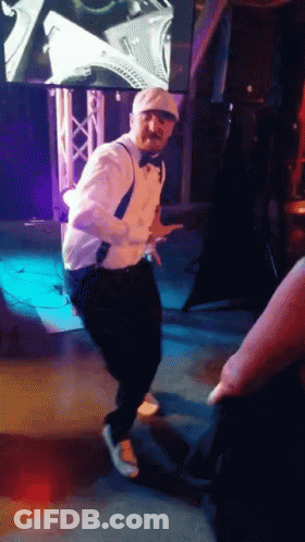 Man In Tuxedo Dancing On Stage GIF