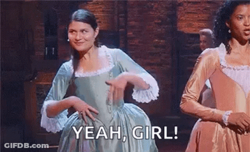 Man In Tuxedo Dancing On Stage In Front Of Man Lying On Table GIF