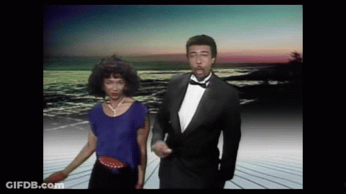 Man In Tuxedo Dancing With Woman In Blue Top GIF