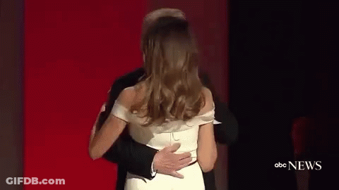 Man In Tuxedo Dancing With Woman In White Dress On Red Carpet GIF