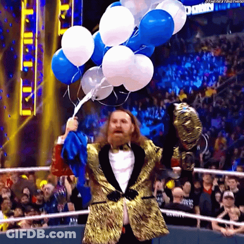 Man In Tuxedo Holding Balloons In Front Of Crowd GIF