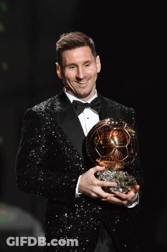 Man In Tuxedo Holding Gold Ball GIF