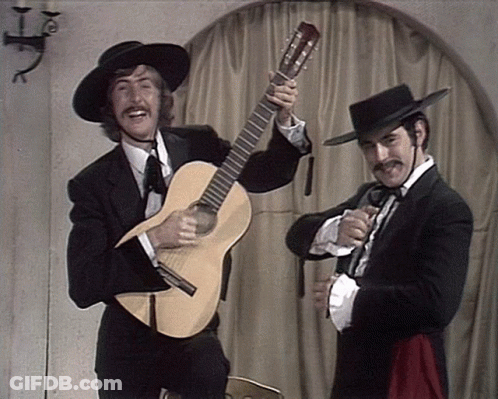 Man In Tuxedo Holding Guitar Beside Man In Hat GIF
