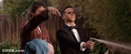 Man In Tuxedo Holding Hose While Another Man Holds Towel GIF
