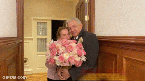 Man In Tuxedo Holding Pink Bouquet GIF