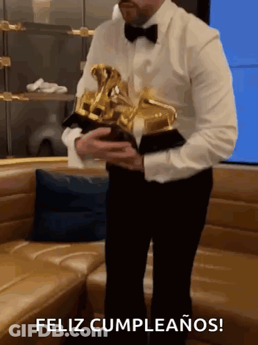 Man In Tuxedo Holding Trophy Feliz Cumpleanos GIF