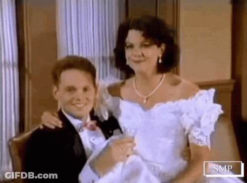 Man In Tuxedo Holding Woman In Wedding Dress GIF
