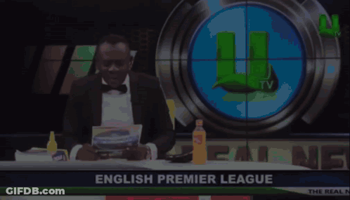 Man In Tuxedo In Front Of English Premier League Screen GIF
