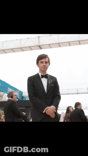 Man In Tuxedo In Front Of Pepsi Sign GIF