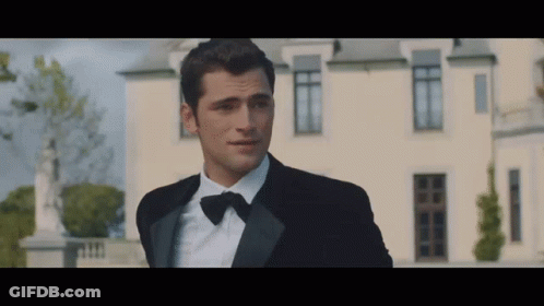 Man In Tuxedo In Front Of White Building GIF
