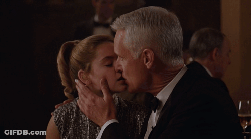 Man In Tuxedo Kissing Woman In Dress GIF