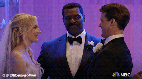 Man In Tuxedo Next To Bride And Groom With NBC Logo GIF