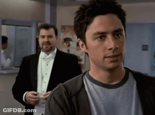 Man In Tuxedo Next To Man In Sweater GIF