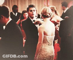 Man In Tuxedo Next To Woman In Dress GIF
