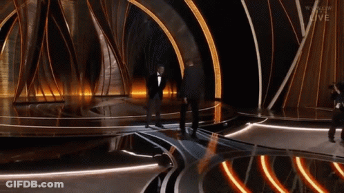 Man In Tuxedo On Stage With Cameraman And Live GIF