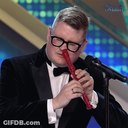 Man In Tuxedo Playing Red Recorder With Talent GIF