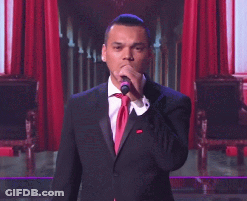 Man In Tuxedo Singing Into Microphone GIF