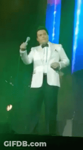 Man In Tuxedo Singing Into Microphone GIF