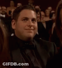 Man In Tuxedo Sitting In Crowd Clapping GIF