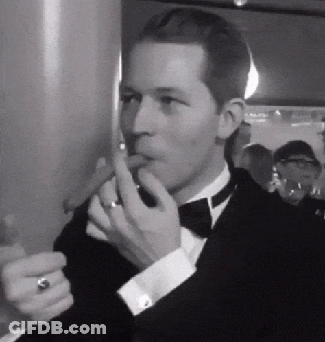 Man In Tuxedo Smoking Cigar With Ring GIF