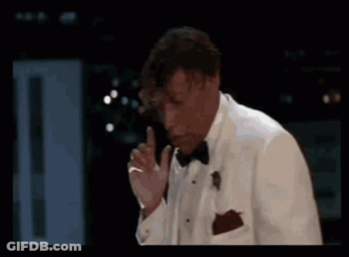 Man In Tuxedo Smoking Cigarette In Dark Room GIF