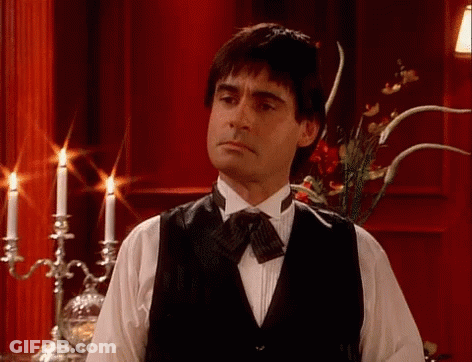 Man In Tuxedo Standing In Front Of Candle Holder GIF