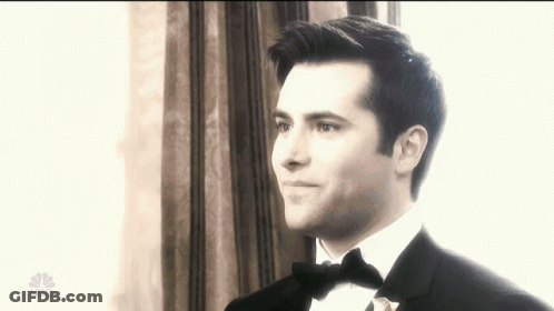 Man In Tuxedo Standing In Front Of Window With NBC Logo GIF