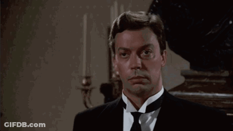Man In Tuxedo Standing In Room With Candles GIF