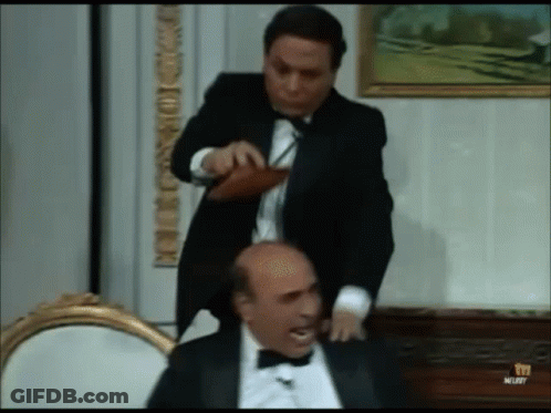 Man In Tuxedo Standing Next To Another Man GIF