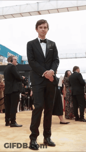 Man In Tuxedo Standing On Red Carpet GIF