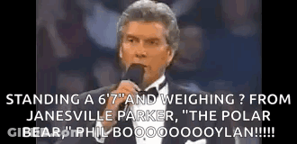 Man In Tuxedo Talking At Microphone GIF
