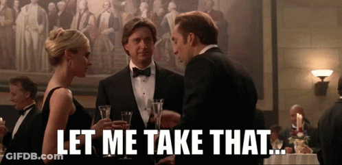 Man In Tuxedo Talking To Woman In Black Dress Saying Let Me Take That GIF