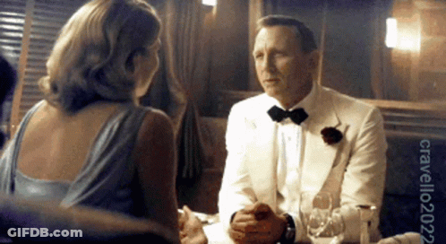 Man In Tuxedo Talking To Woman In Blue Dress GIF
