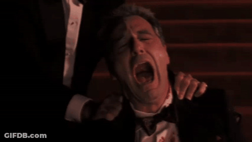 Man In Tuxedo With Blood Being Held GIF