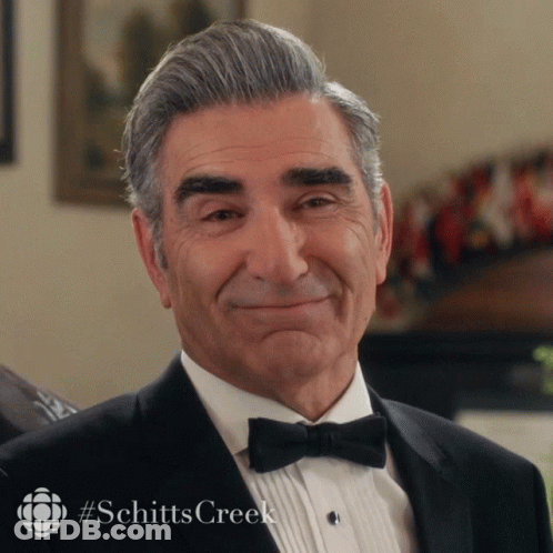 Man In Tuxedo With Bow Tie Smiling With Schitts Creek GIF